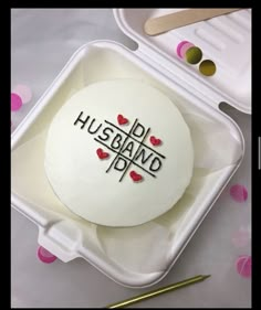 a cake in a box with the words husband on it and some scissors next to it