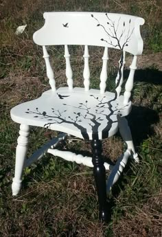 a white chair sitting on top of a grass covered field