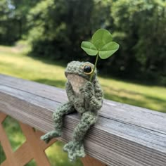 crochet frog sitting on a wooden fence holding a clover Frog Sweater Crochet Pattern, Crochet Soft Animals, Sew Frog Pattern, Crocheted Frog Pattern, Free Cute Crochet Amigurumi Patterns, Crochet Frog Ideas, Crochet Frog Stuff, Cool Crochet Animals, How To Create A Crochet Pattern