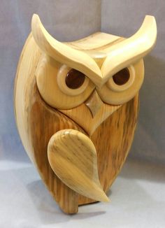 an owl statue made out of wood on a white background