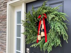 a christmas wreath with bells hanging on the front door