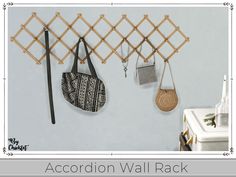 the wall rack has three purses hanging on it