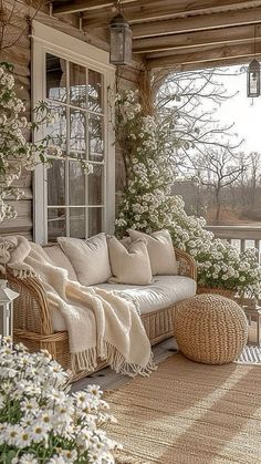 the porch is decorated with wicker furniture and flowers