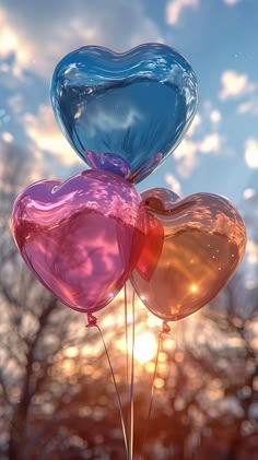 three heart shaped balloons floating in the air