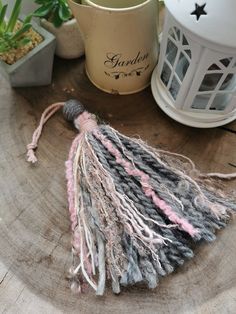 the tassels are made from yarn and other things on top of a tree stump