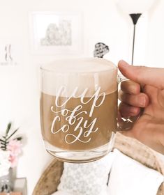 a person holding a cup of coffee in their hand with the words cup of joy written on it