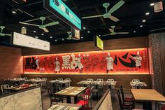 the interior of a restaurant with red walls and ceiling fans hanging from it's ceiling