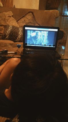 a woman laying down with her head on the laptop