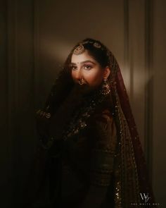 a woman wearing a veil in the dark with light shining on her face and head