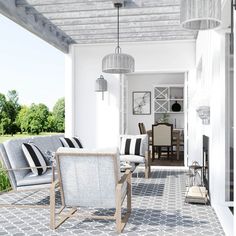 a porch with chairs, tables and lamps on the side walk that leads to an outdoor dining area