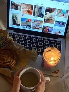 a person holding a cup of coffee in front of a laptop with pictures on the screen