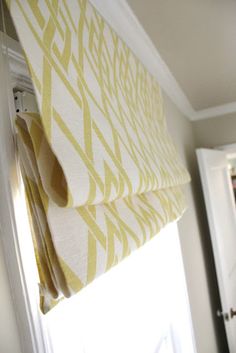 a yellow and white curtain hanging from the side of a window