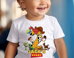 a young child wearing a white shirt with the number two on it and cartoon characters