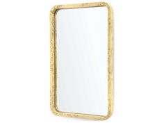 a gold framed mirror sitting on top of a white wall