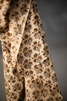 the back of a woman's dress with flowers on it, hanging from a hanger