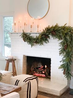 a living room filled with furniture and a fire place covered in greenery next to a fireplace