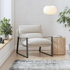 a white chair sitting on top of a wooden floor next to a potted plant