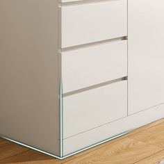 a white cabinet with three drawers on the bottom and one drawer in the middle, sitting on a hard wood floor