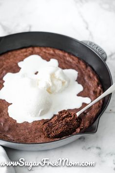 a chocolate cake in a pan with whipped cream on top