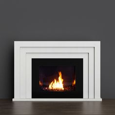 a white fireplace with flames burning in it