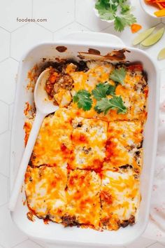 a casserole dish with cheese, meat and vegetables in it on a table