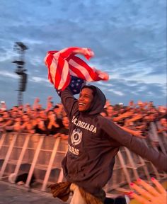 a man holding an american flag in front of a crowd