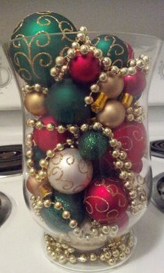 a glass vase filled with ornaments on top of a stove