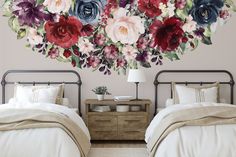 two beds in a bedroom with floral wall decals