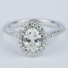 an oval cut diamond ring with halos on the band