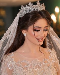 a woman in a wedding dress with a tiara on her head and veil over her face