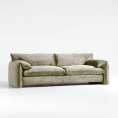 a couch sitting on top of a white floor next to a wall with a light colored background