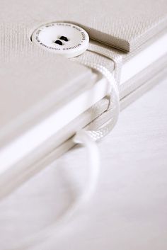 a button is attached to the side of a white bedding set with linens