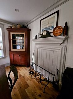 a living room with a fireplace and wooden flooring next to a wall mounted clock