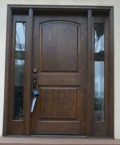 a wooden door with two glass panes on the front and side sides, in an exterior setting