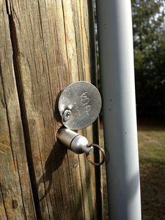 a metal door handle on a wooden fence