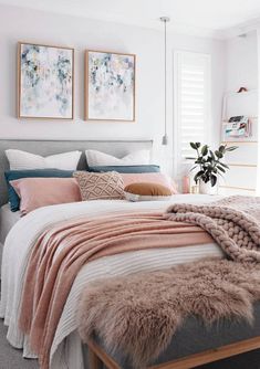 a bed with blankets and pillows on top of it in a bedroom next to a window