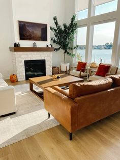 a living room filled with furniture and a fire place in front of a large window