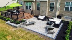 a patio with chairs, tables and an umbrella