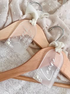 two wooden hangers with personalized tags on them