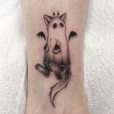 a cat tattoo on the ankle with bats around it