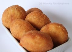 a white bowl filled with doughnuts on top of a table