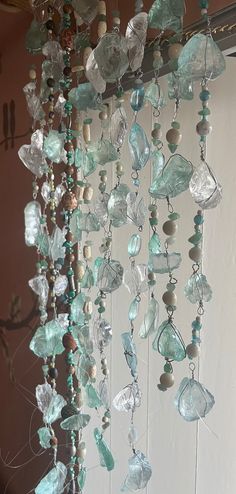 a wind chime hanging from the side of a building with lots of glass beads