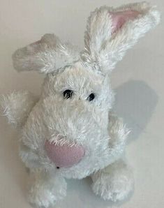 a white stuffed rabbit sitting on top of a table