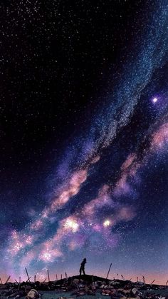 a man standing on top of a hill under the stars