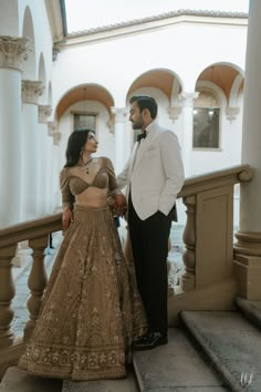 a man in a tuxedo standing next to a woman in a gold dress