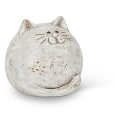 a white cat figurine sitting in front of a white background and looking at the camera