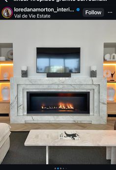 a living room with a fire place in the center and a tv above it on top of a fireplace