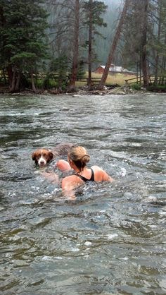 a woman and her dog are swimming in the water