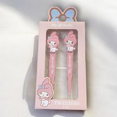 two pink toothbrushes with hello kitty designs in a box on a white surface