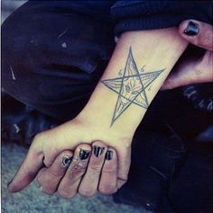 a woman's hand with a star tattoo on it